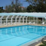 Piscine avec bâche de protection dans un jardin verdoyant
