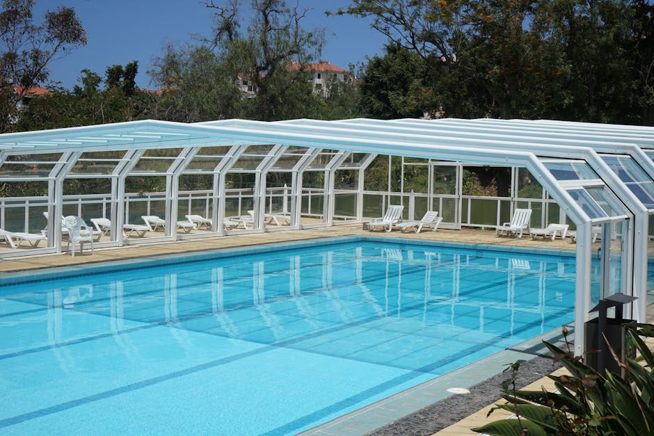 Piscine avec bâche de protection dans un jardin verdoyant
